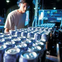 Factory worker running the assembly line for canned Welch's drinks