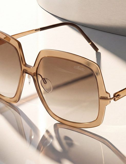 Close-up of a lightweight rectangular sunglass frame in warm brown tones, highlighting fine detailing, smooth surfaces, and gradient lenses.