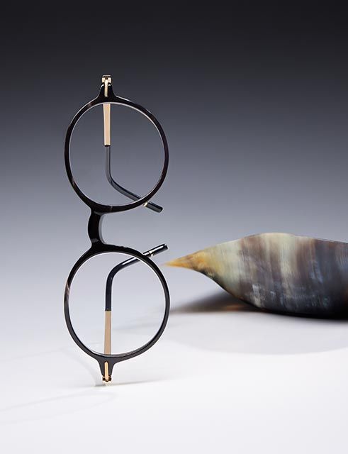 Horn eyewear standing upside down beneath a horn sculpture