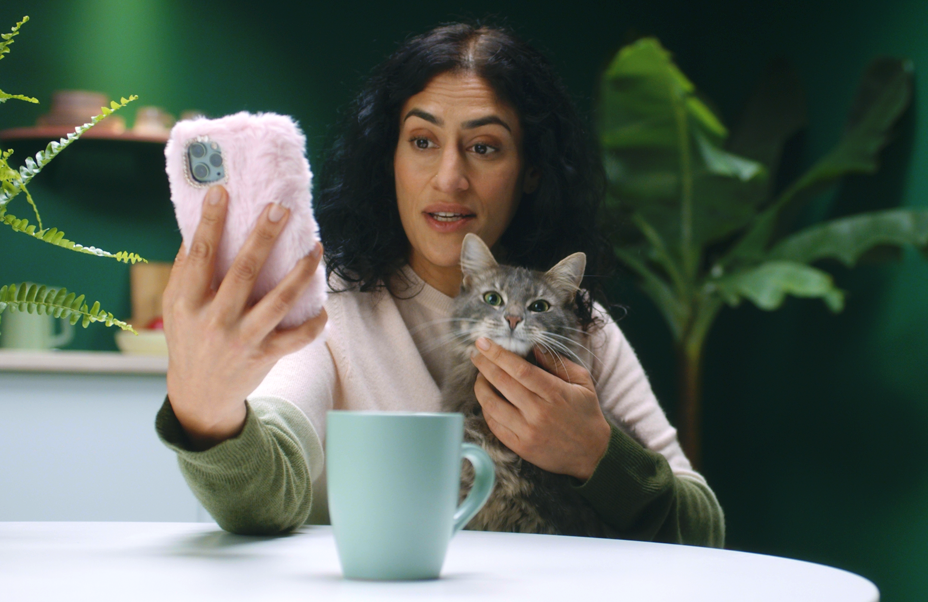 Woman taking a selfie with a cat and a mug