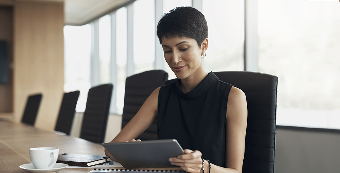 Corporate woman looking at tablet on the table