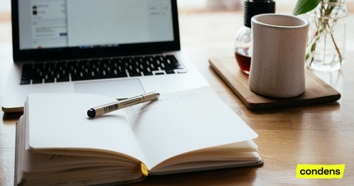 Notebook, pen and laptop on a table