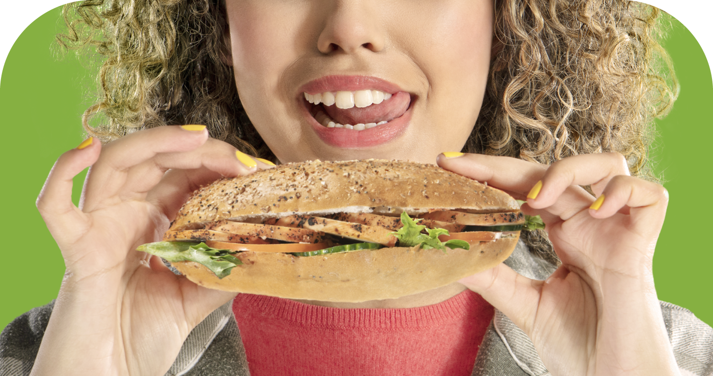 A woman holding a chicken salad sandwich